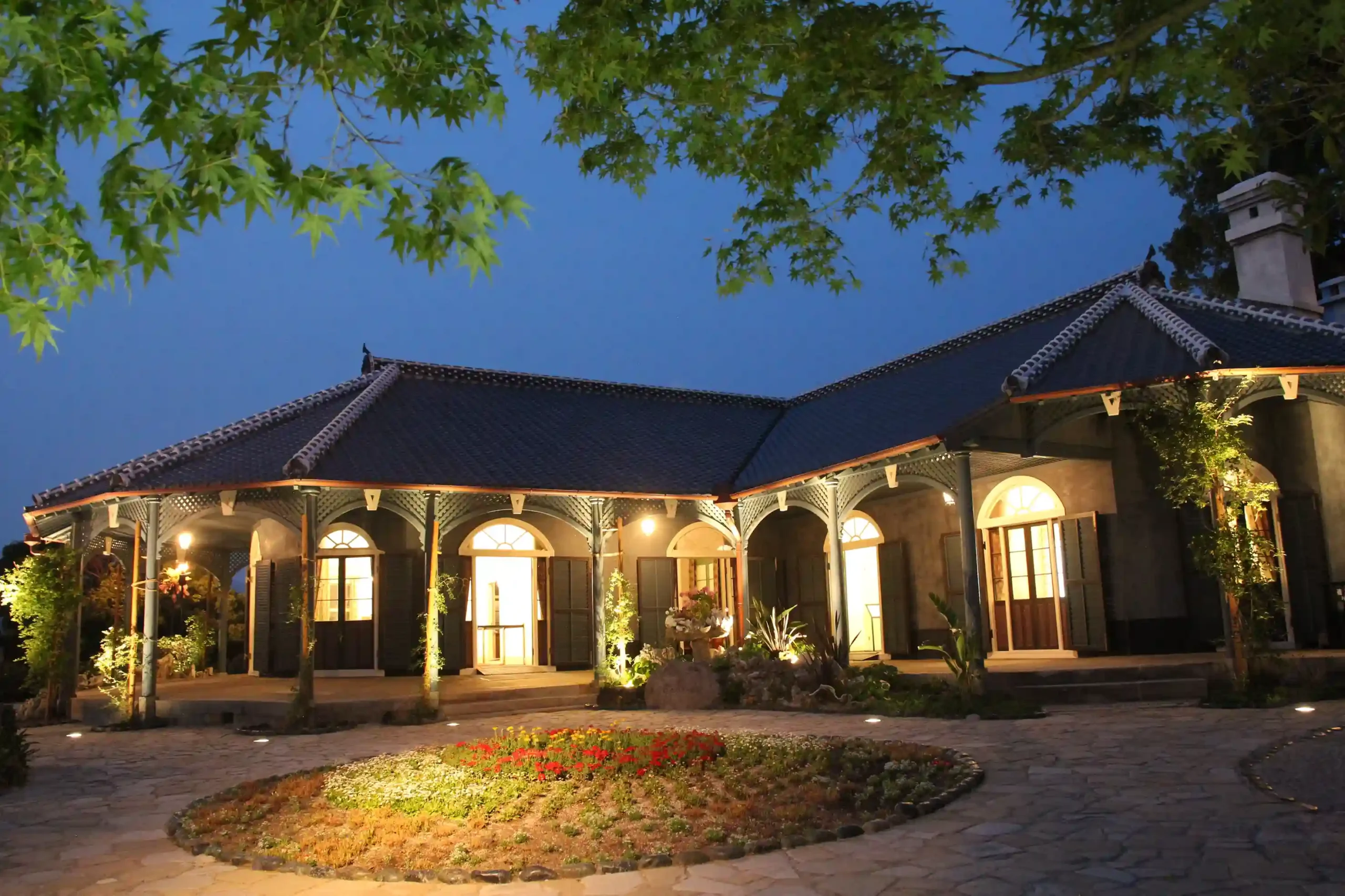 Illuminated Former Glover House at night in Nagasaki, a historic Western-style residence with scenic