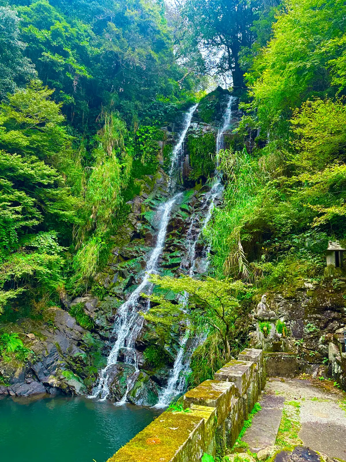 Twin waterfall flowing side by side in a forested valley in Nagasaki, creating a serene and spiritua