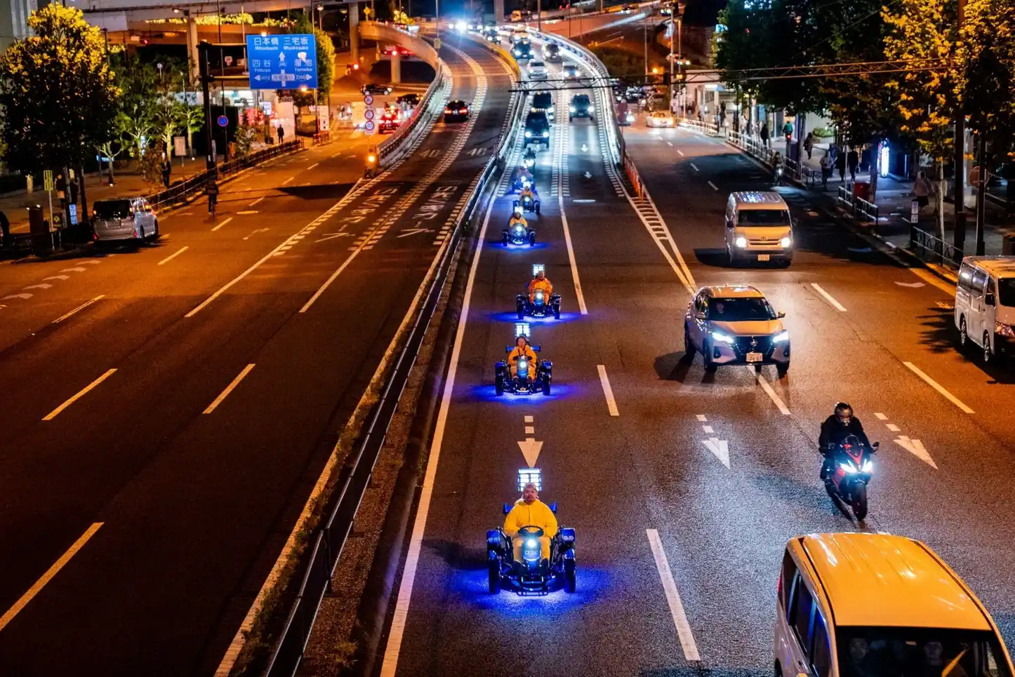 Street go-karts driving side by side on a city road at night in Japan