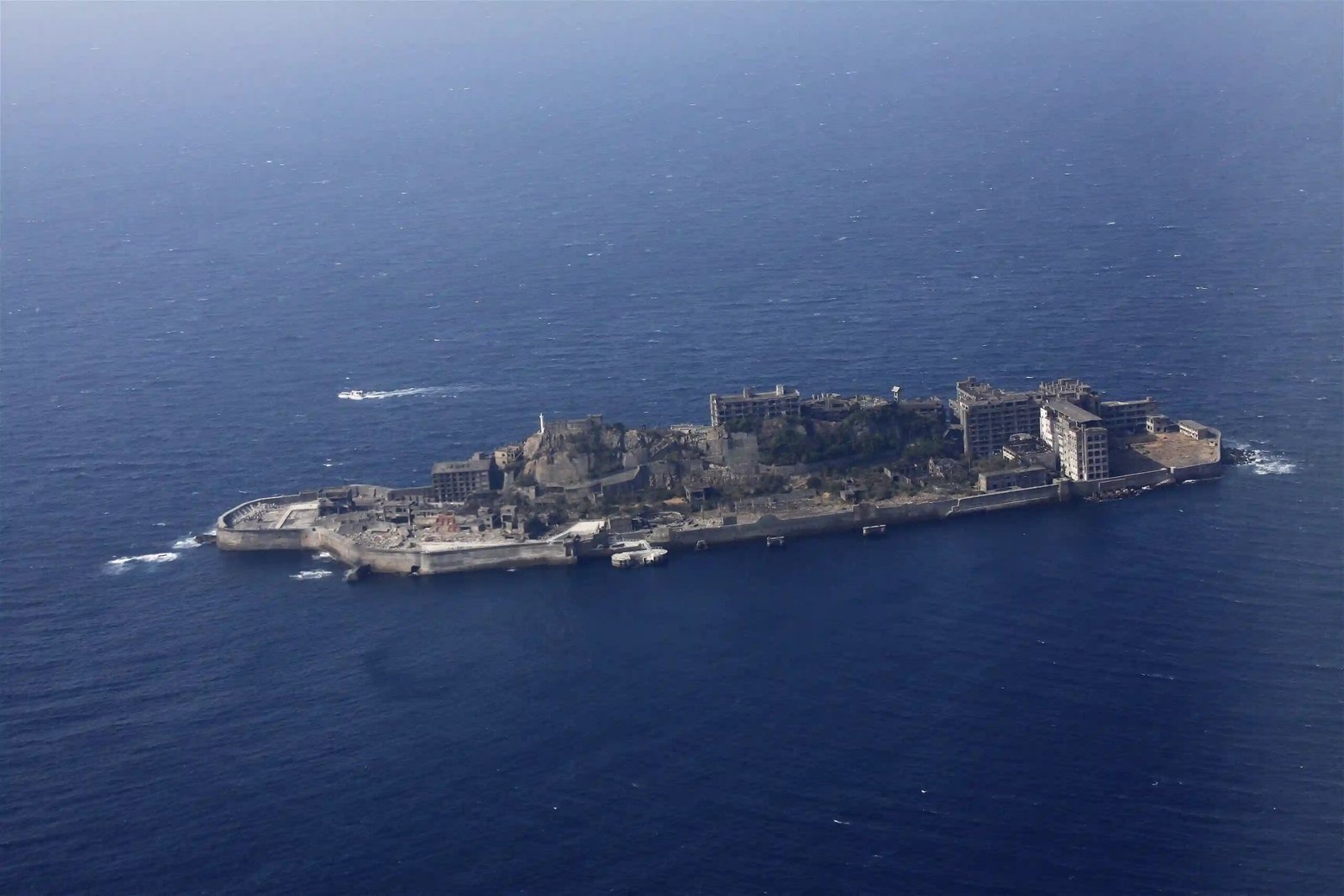 Wide aerial view of Gunkanjima (Hashima Island) off the coast of Nagasaki, revealing its battleship-