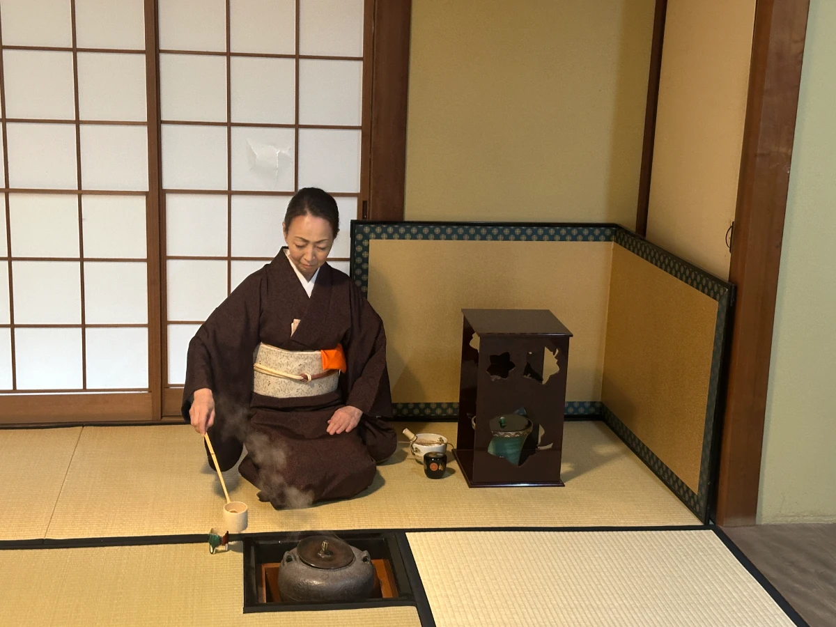 Woman preparing matcha tea during a traditional Japanese tea ceremony experience